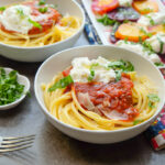 bucatini pasta with marinara sauce in a white bowl