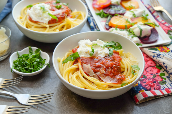bucatini pasta with marinara sauce in a white bowl