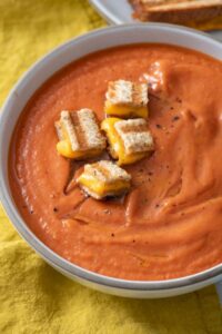 Roasted tomato soup topped with grilled cheese croutons