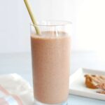 Chocolate peanut butter smoothie in a glass with a straw