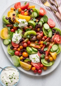 Heirloom tomato salad with cucumber, olives and feta on a platter