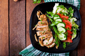 Sliced chicken paillard with a cucumber and tomato salad
