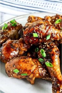 Sticky glazed chicken topped with sesame seeds and scallions