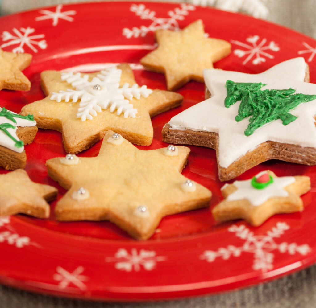 Decorated star-shaped sugar cookies on a red plate