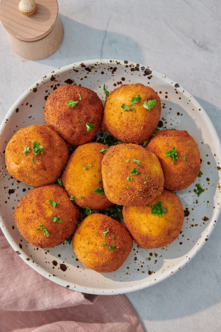 Golden fried turkey potato croquettes garnished with parsley on a speckled plate