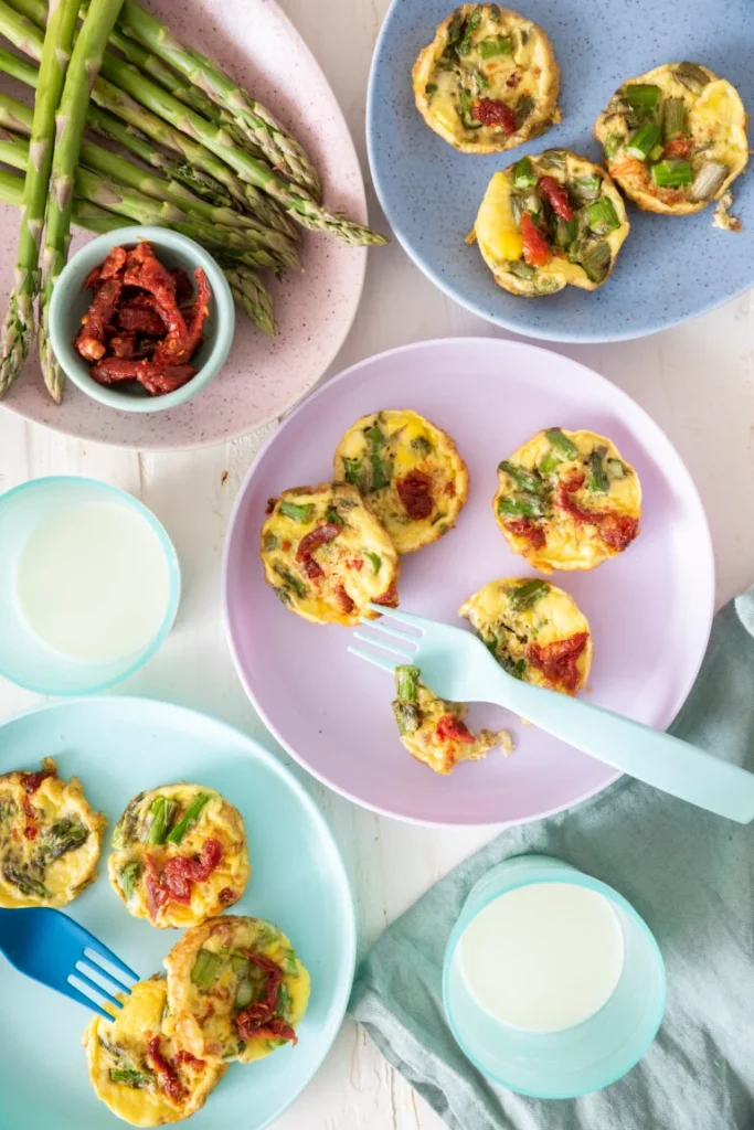 Baby frittata egg bites with asparagus on colorful plates
