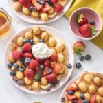 Bubble waffles topped with berries and whipped cream