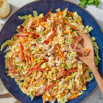 Chinese chicken salad with cabbage, carrots and peppers on a blue platter