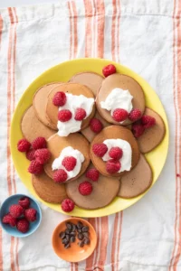 Chocolate pancakes topped with yogurt and raspberries