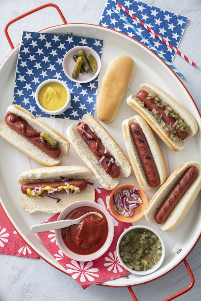 Hot dog bar with buns and bowls of ketchup, mustard and relish