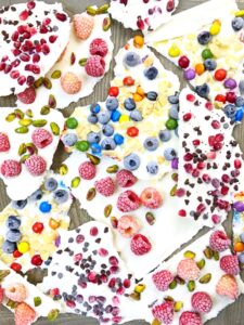 Frozen yogurt bark pieces topped with berries and pistachios