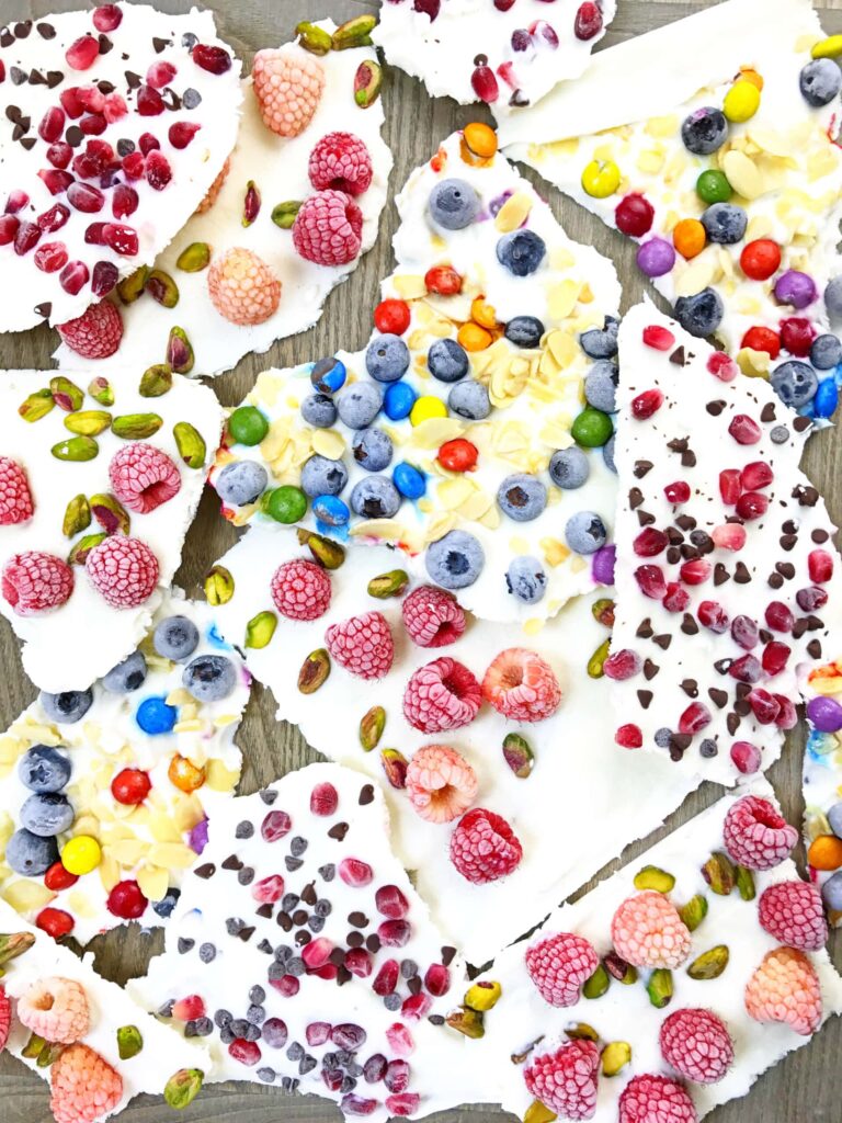 Frozen yogurt bark pieces topped with berries and pistachios