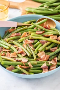 Sautéed green beans with bacon in a blue bowl