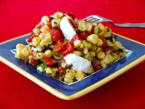 Grilled corn and red pepper salad on a blue plate