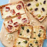Matzah pizzas topped with mozzarella, pepperoni and olives