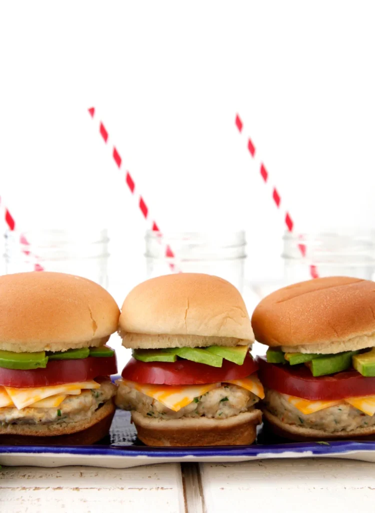 Three Mexican chicken sliders with avocado and tomato