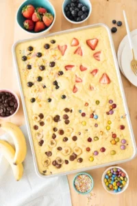 Sheet pan pancake topped with strawberries and chocolate chips