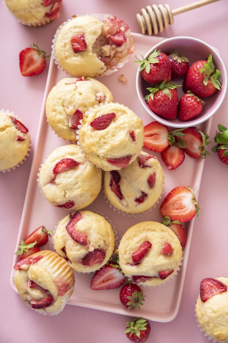 Strawberry muffins on a pink tray with fresh strawberries
