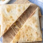 Crispy folded bean and cheese tortilla pillows cut in half