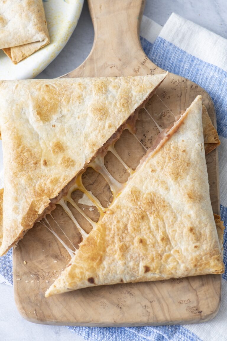 Crispy folded bean and cheese tortilla pillows cut in half