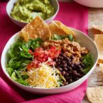 Ground turkey taco bowl with lettuce, black beans, tomatoes and shredded cheese