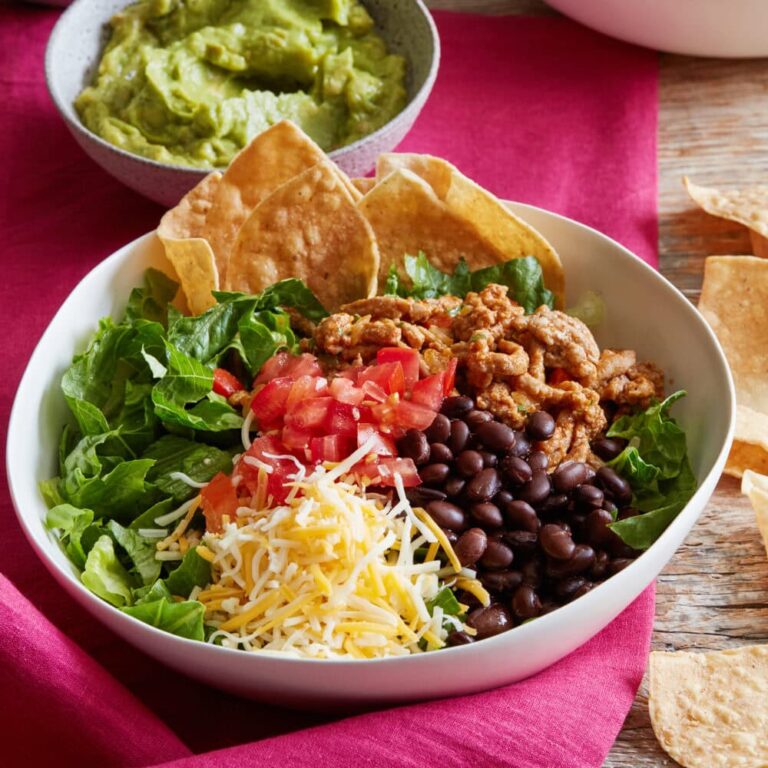 Ground turkey taco bowl with lettuce, black beans, tomatoes and shredded cheese