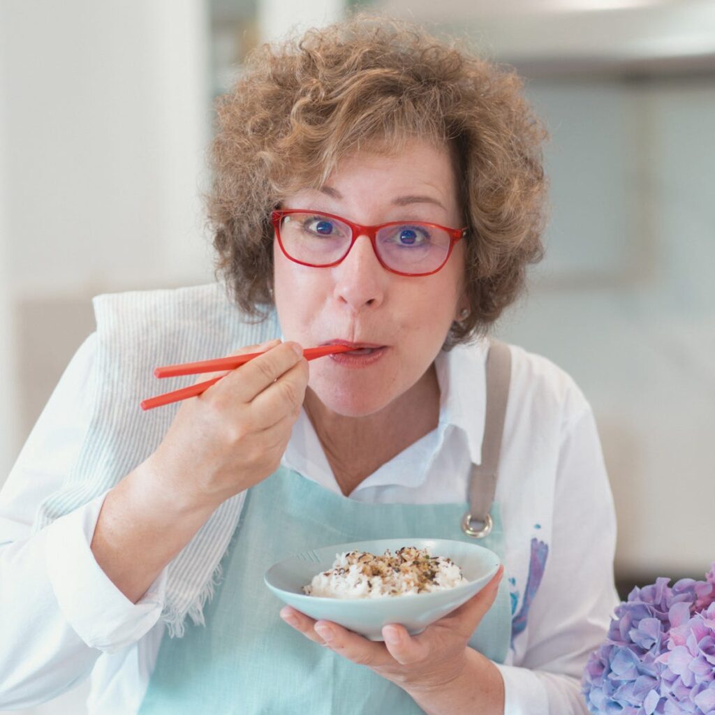Beth A. Lee eating rice with red chopsticks
