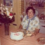 Ellen’s mother at a table with a decorated cake