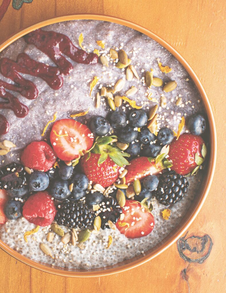 a breakfast bowl with porridge, strawberries and blueberries