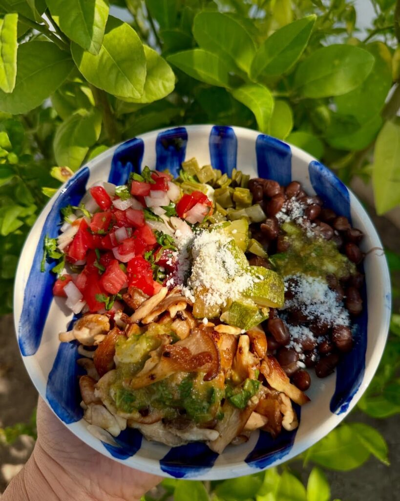 A striped blue and white bowl filled with colorful, homemade food inspired by traditional Mexican dishes