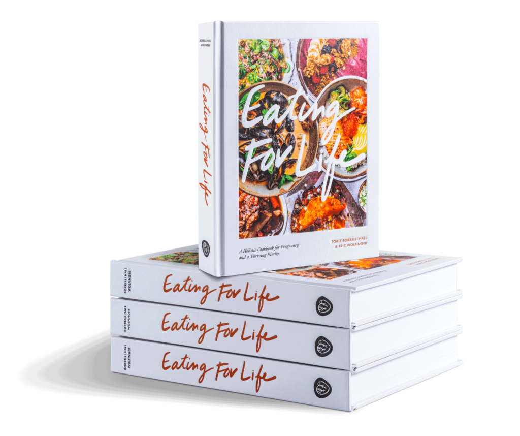 Eating for Life: A Holistic Cookbook for Pregnancy and a Thriving Family by Torie Borrelli Hall and Eric Wolfinger, stack of books