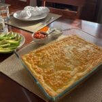 Eggs California served in a glass casserole dish, with sliced avocado, salsa, and sour cream on the side