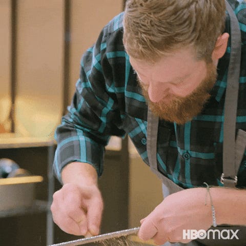 Gif of a white man in a kitchen using a microplane