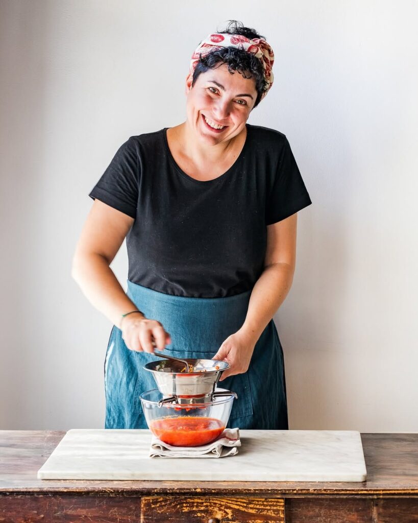 Giulia Scarpaleggia wearing a black t shirt and prepping food in the kitchen