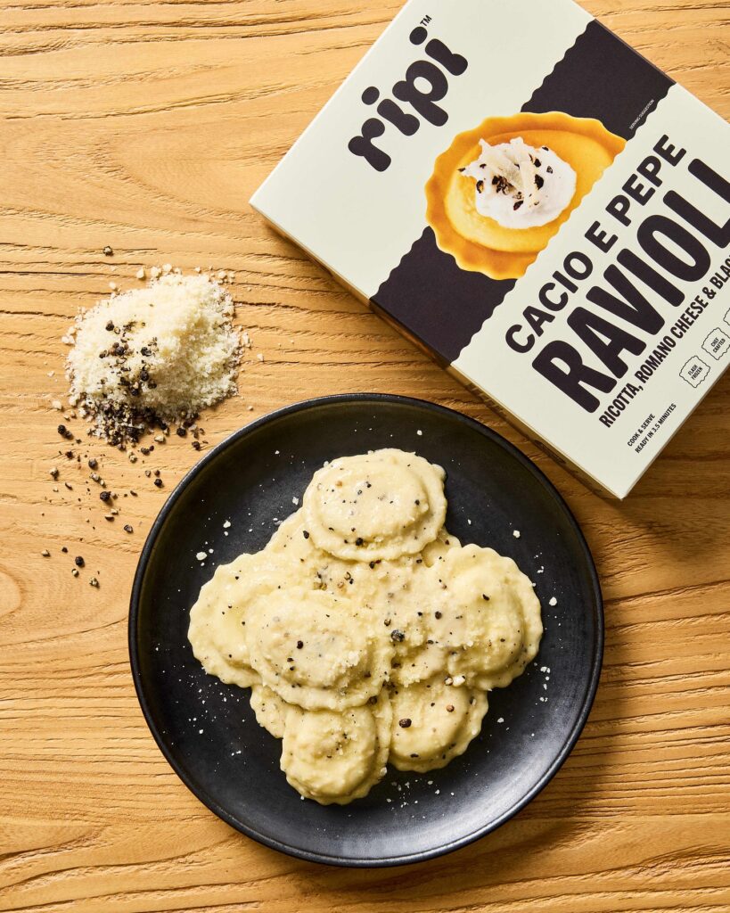 Ripi cacio e pepe ravioli on a black plate