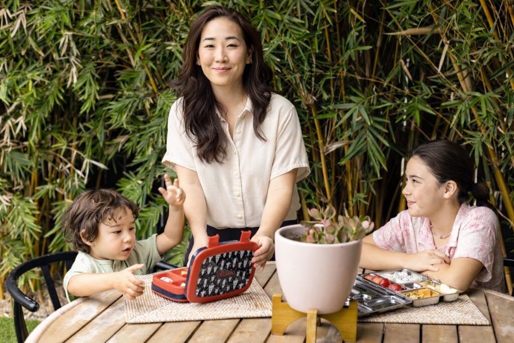 Jane Nicholson outside with her son and daughter eating snacks