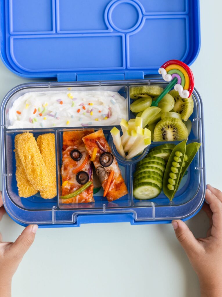 Rainbow Naan Pizza and veggies in a blue Lunchbox