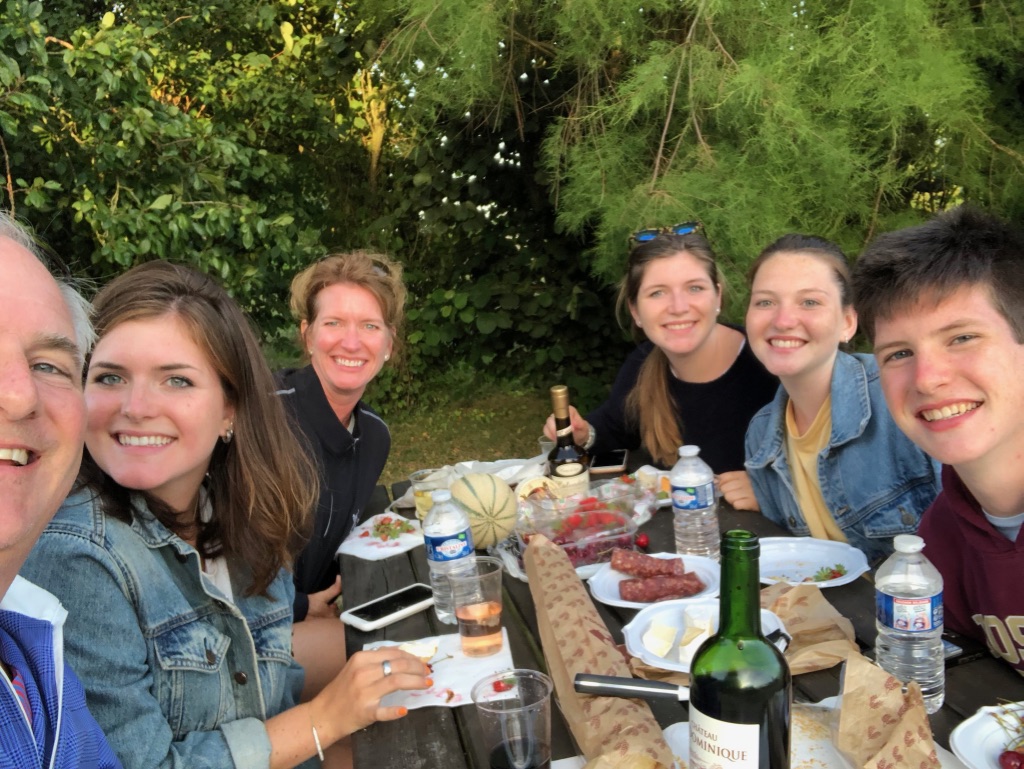 Jill and her husband eating dinner outside with their four adult kids