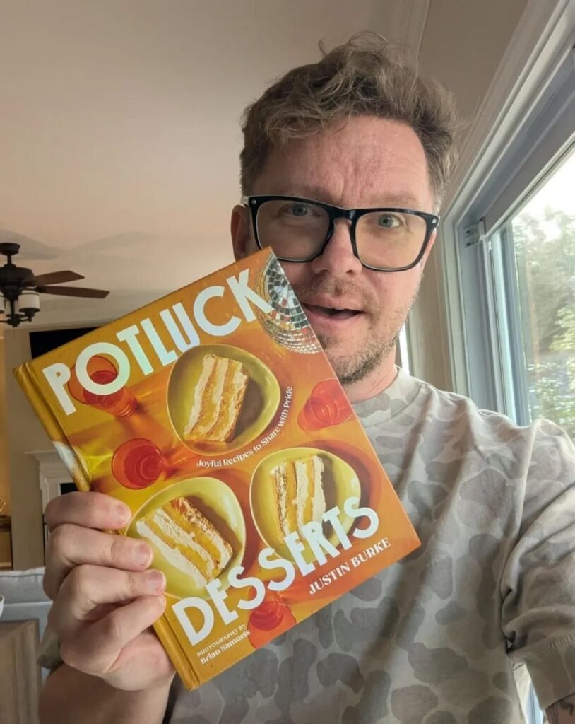 Justin holding his cookbook, Potluck Desserts