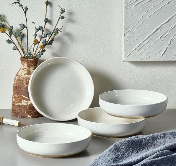 4 shallow white bowls displayed on a gray countertop