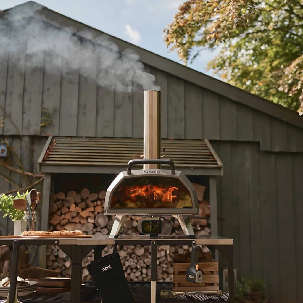 Wood and gas Ooni pizza oven with chimney stack outdoors