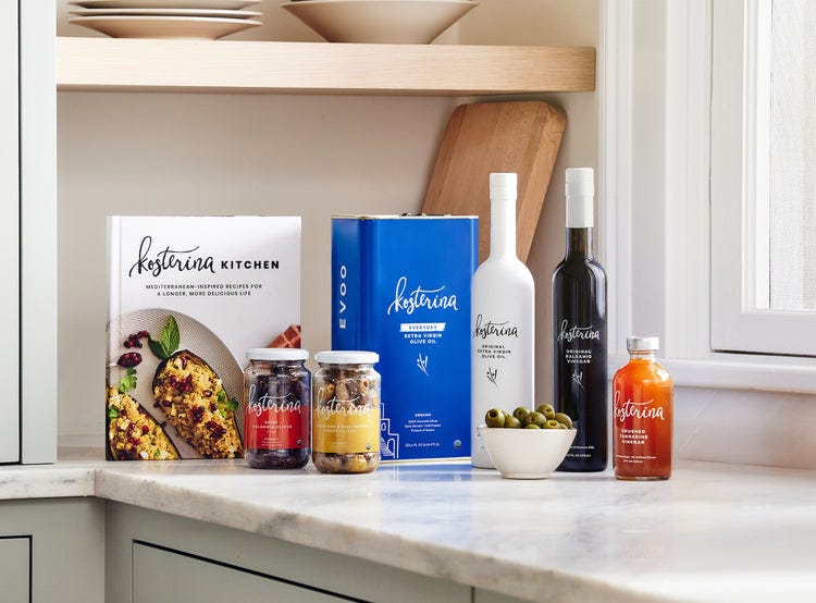 Kosterina olive oils, pantry goods and cookbook on a kitchen counter