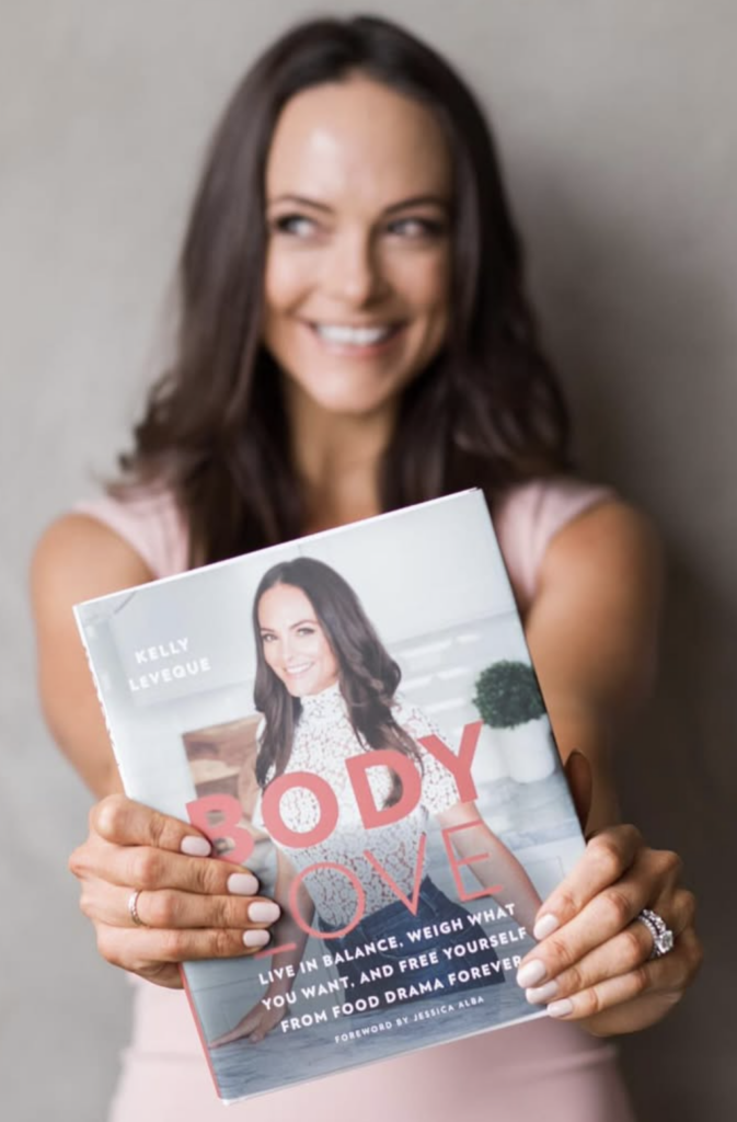 Kelly LeVeque holding her book Body Love