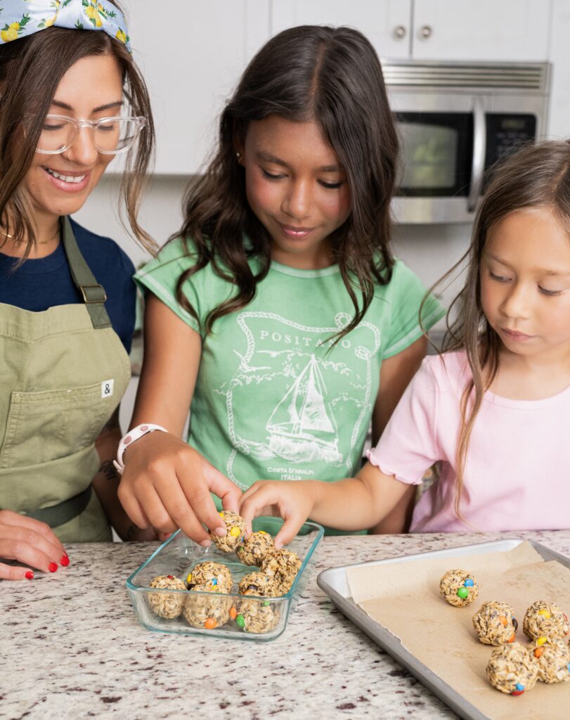 Kris and her daughters prepping snacks in a glass container