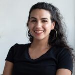 Portrait of Krista Linares, smiling, in a black T-shirt