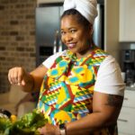 Chef Liesha McKinley-Barnett in a colorful apron in her kitchen