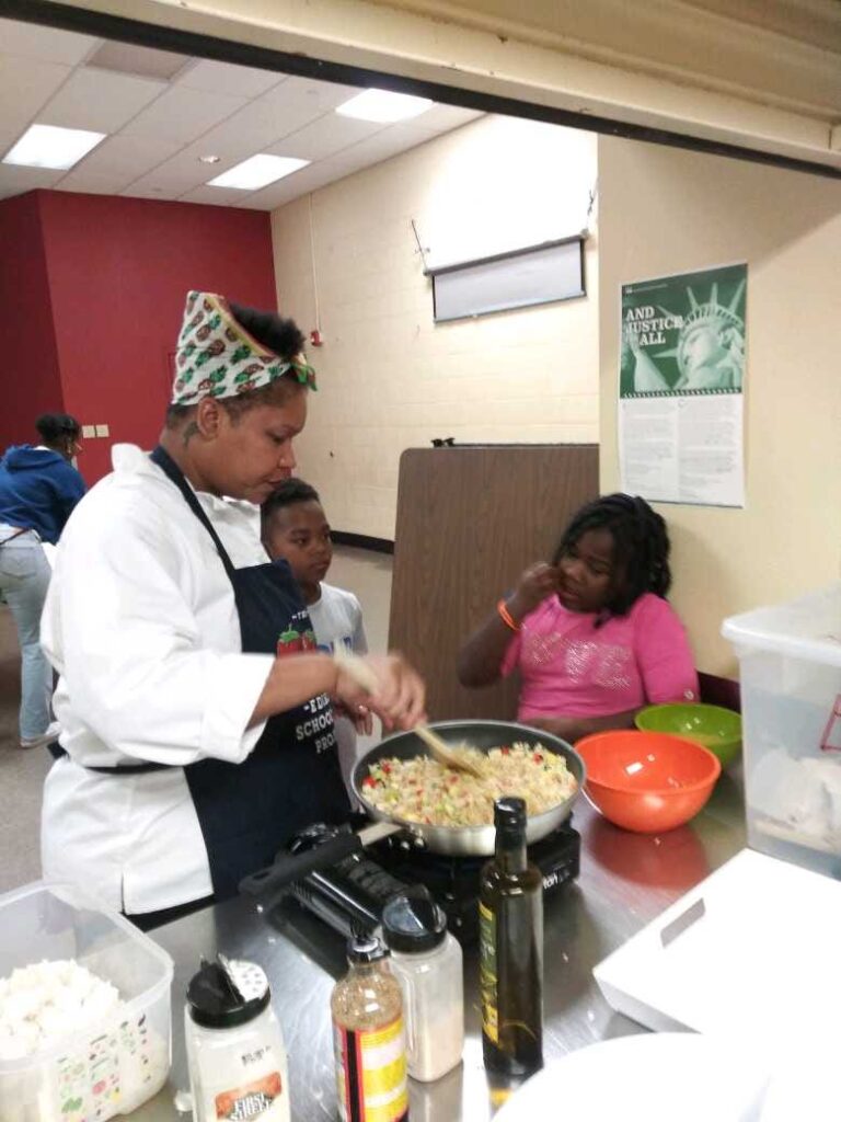 Chef Liesha McKinley-Barnett cooking with kids in a community kitchen