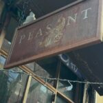 Peasant's restaurant sign in brown with white lettering and picture of a peasant