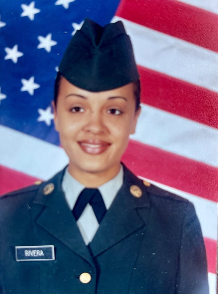 Marta Rivera Diaz in uniform in front of an American Flag