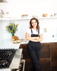Micah Siva standing in the kitchen wearing a white t shirt and overalls